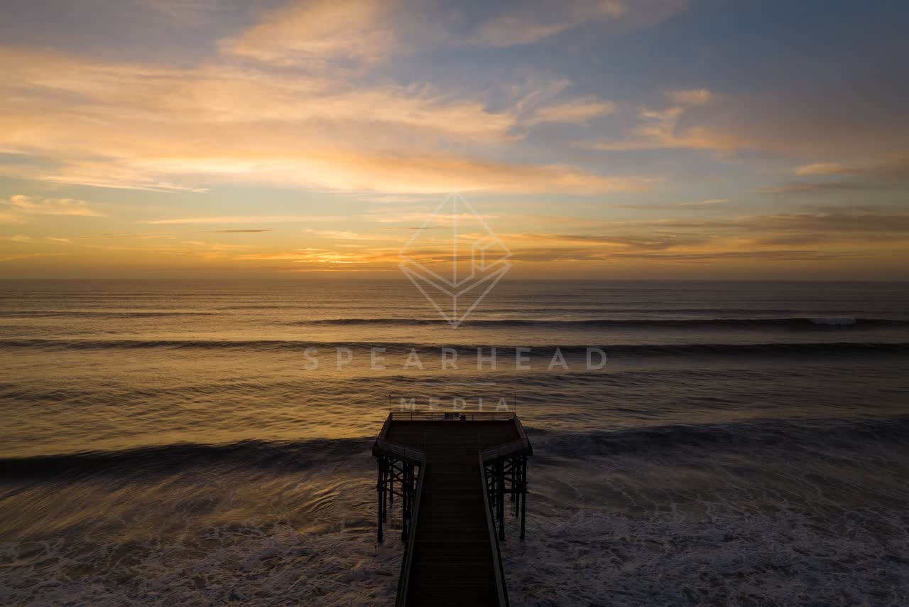 Low aerial view of the beach, the surf and the pier in Pacific Beach.