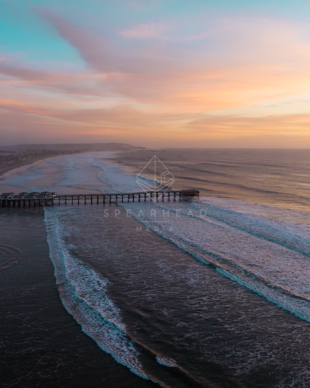 Aerial view of the beach, the surf and the pier in Pacific Beach.