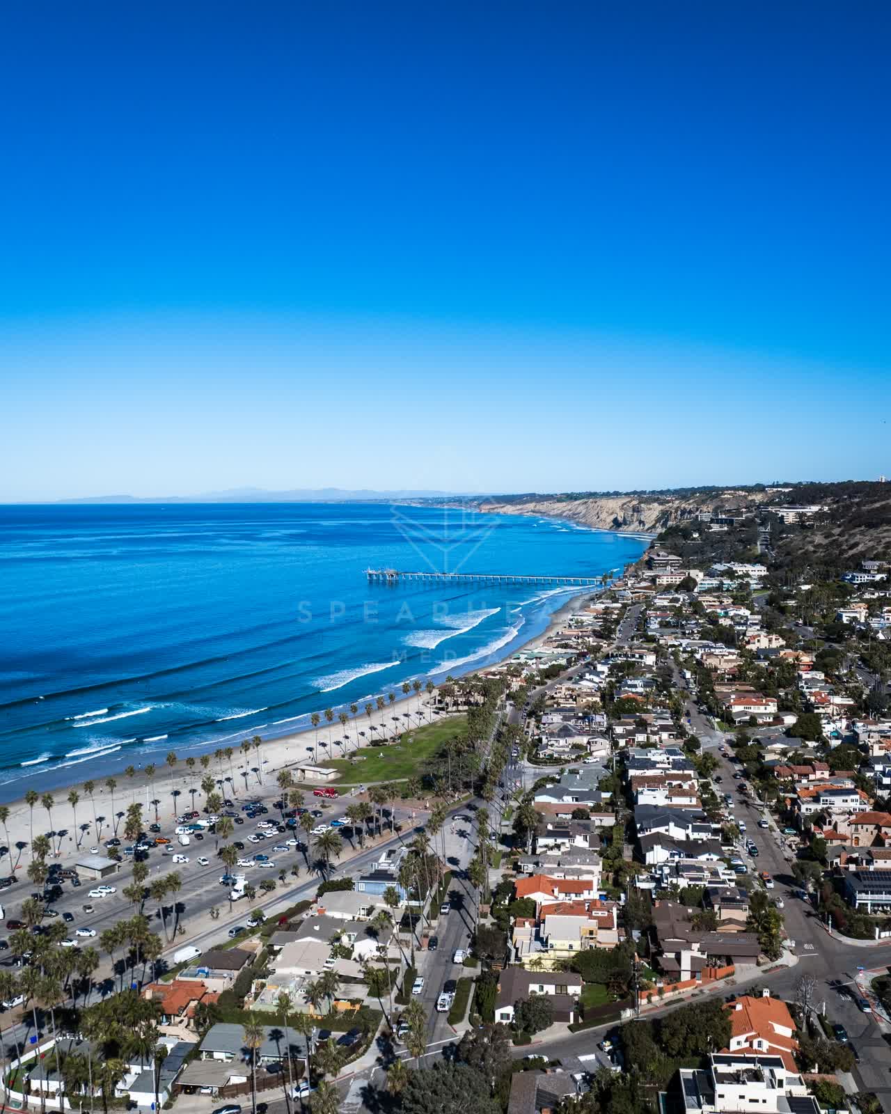 Aerial view of the beach, the surf and the pier at La Jolla Shores.
