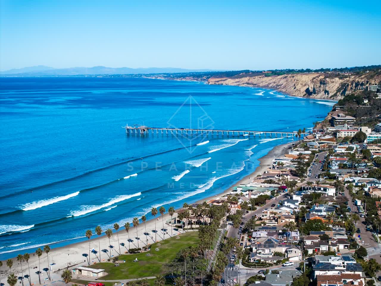 Aerial view of the beach, the surf and the pier at La Jolla Shores.
