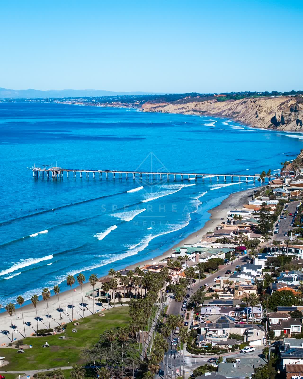 Aerial view of the beach, the surf and the pier at La Jolla Shores.