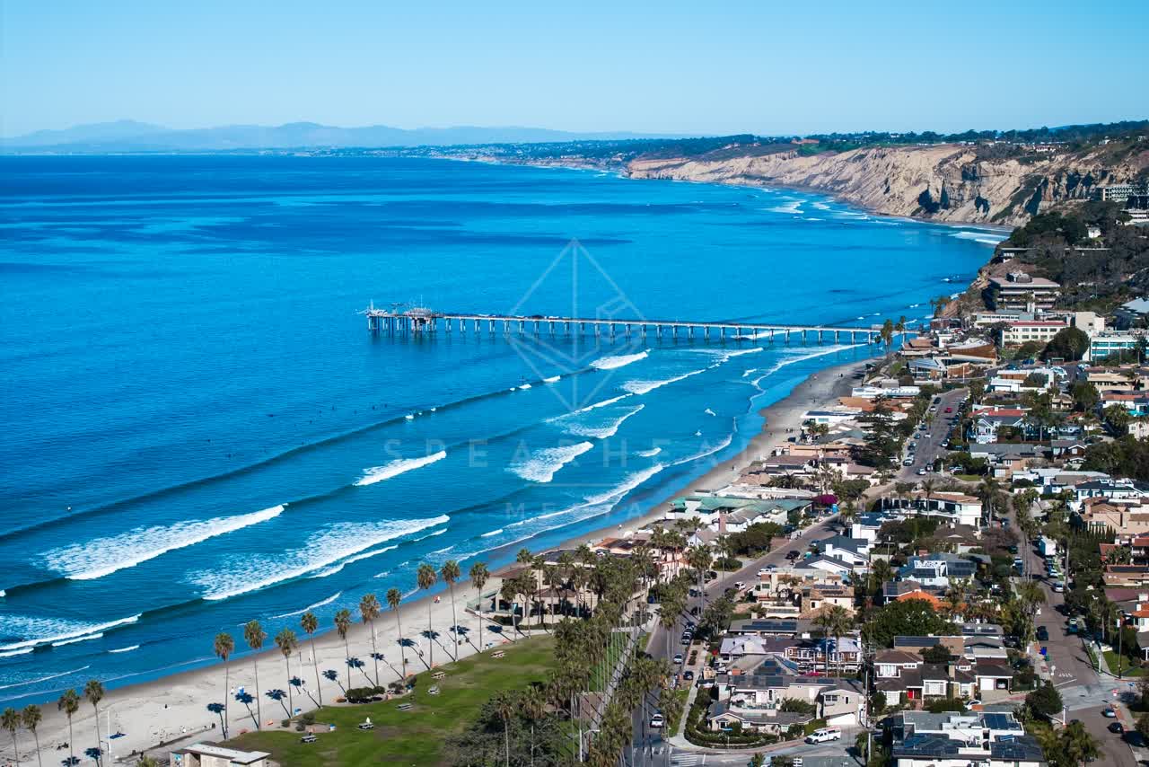 Aerial view of the beach, the surf and the pier at La Jolla Shores.