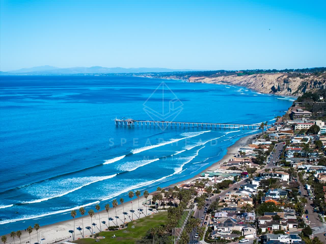 Aerial view of the beach, the surf and the pier at La Jolla Shores.