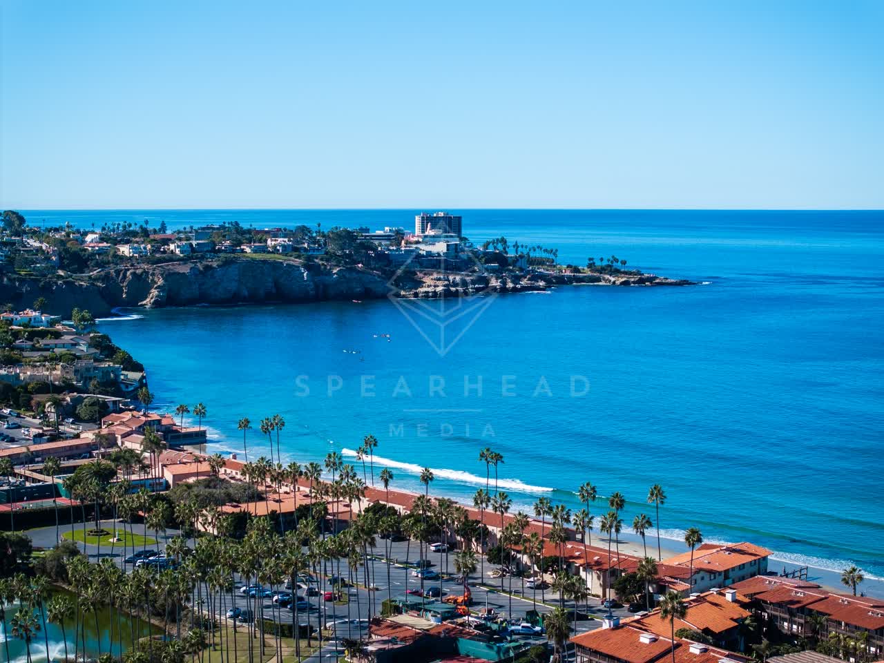 Aerial view of the beach, the surf and palm trees at La Jolla Cove.