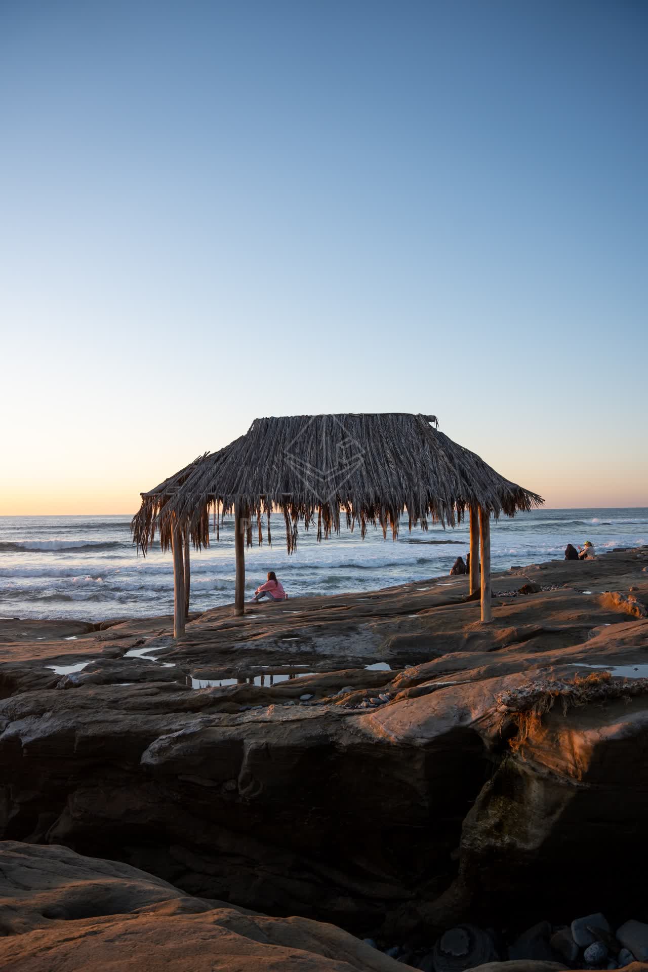 The beach, the surf and the ocean at Windansea, with people walking.
