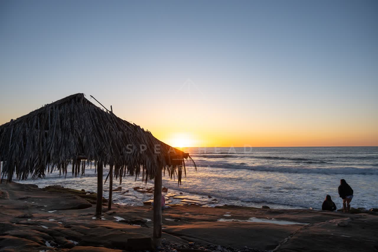 The beach, the surf and the ocean at Windansea, with people walking.