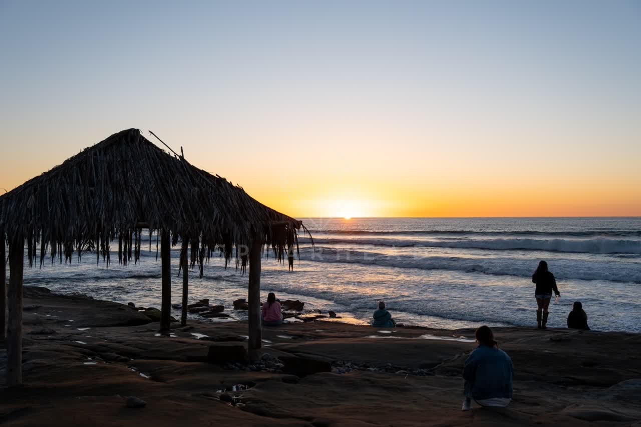 The beach, the surf and the ocean at Windansea, with people walking.
