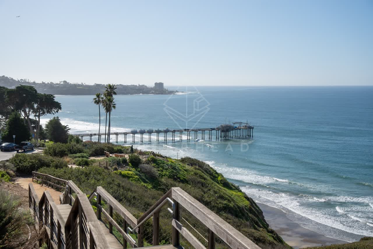 Elevated view of the cliffs, the surf and the pier at La Jolla Shores.