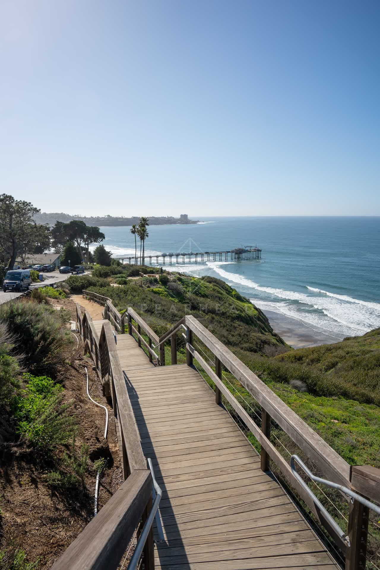 Elevated view of the cliffs, the surf and the pier at La Jolla Shores.
