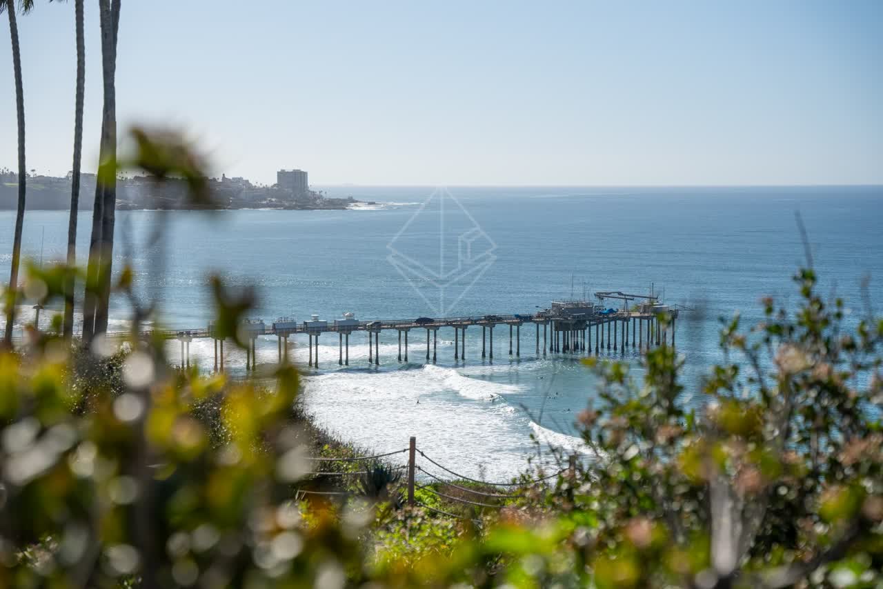 Elevated view of the cliffs, the surf and the pier at La Jolla Shores.