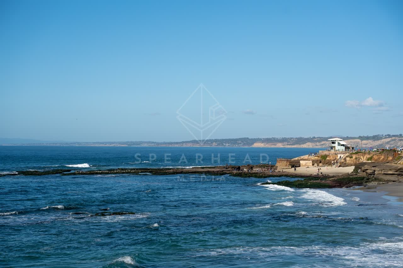 Elevated view of the cliffs, the surf and the ocean at La Jolla Cove.
