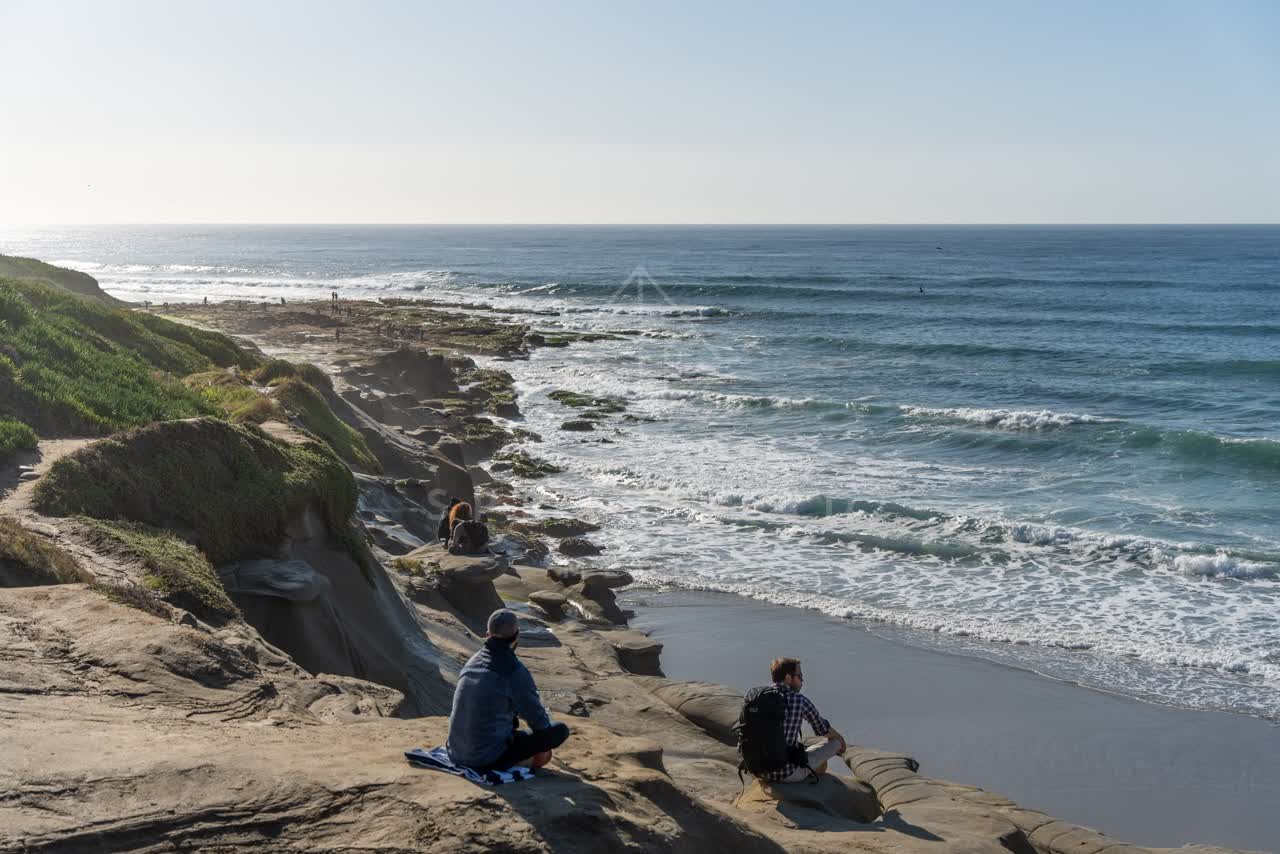 Elevated view of the cliffs, the surf and the ocean at La Jolla Cove.