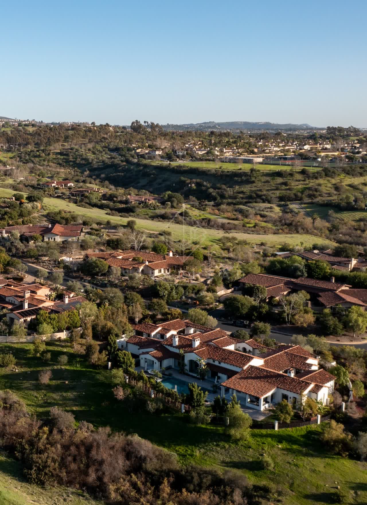 Aerial view of a residential street, homes and the buildings in Black Mountain Ranch.