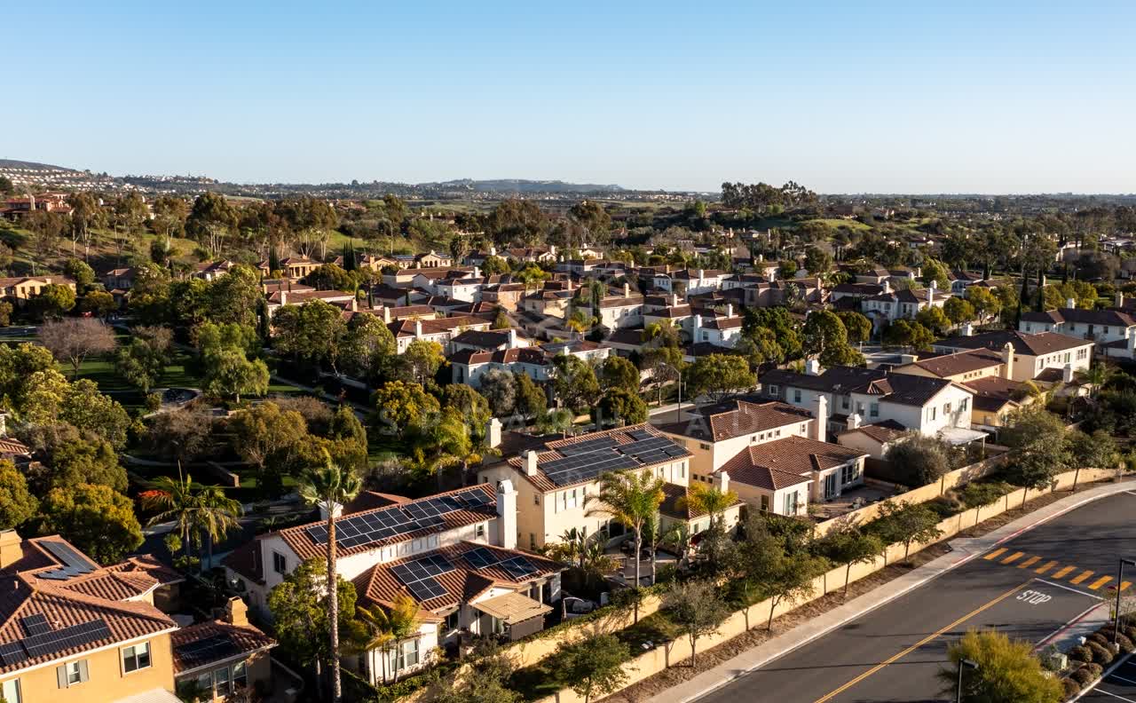 Aerial view of a residential street, palm trees and homes in Black Mountain Ranch.