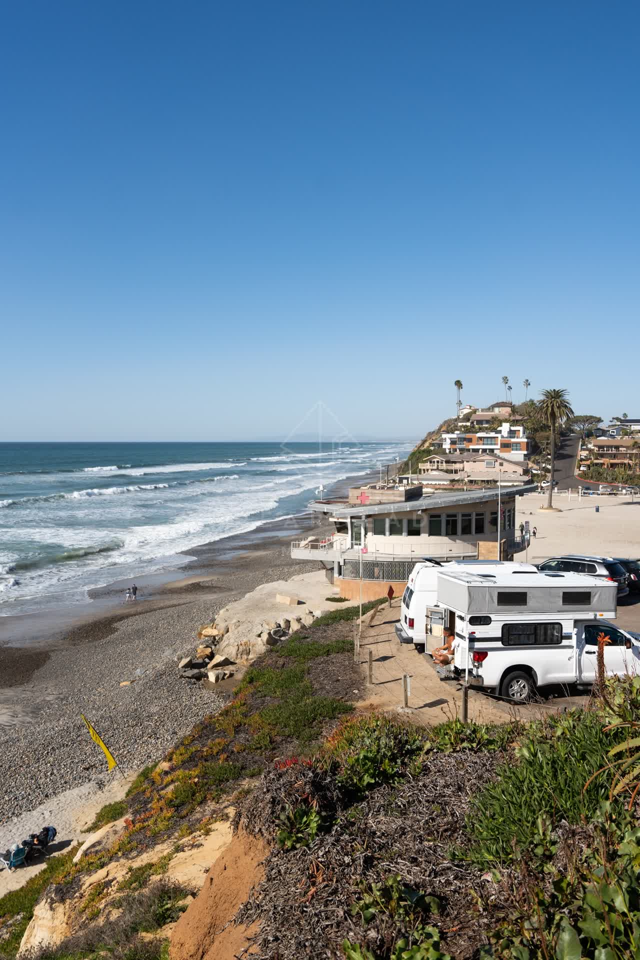 Elevated view of the beach, the surf and palm trees at Moonlight Beach.