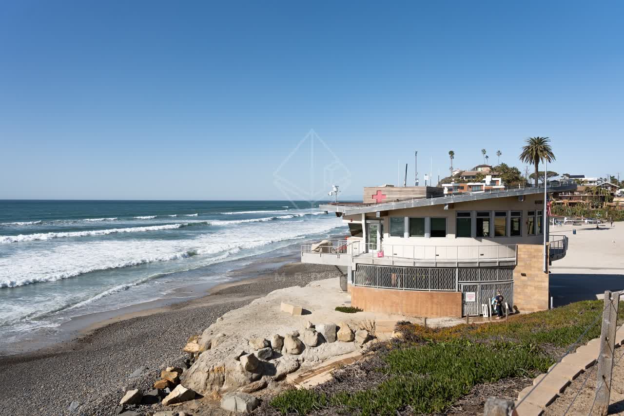 Elevated view of the beach, the surf and palm trees at Moonlight Beach.