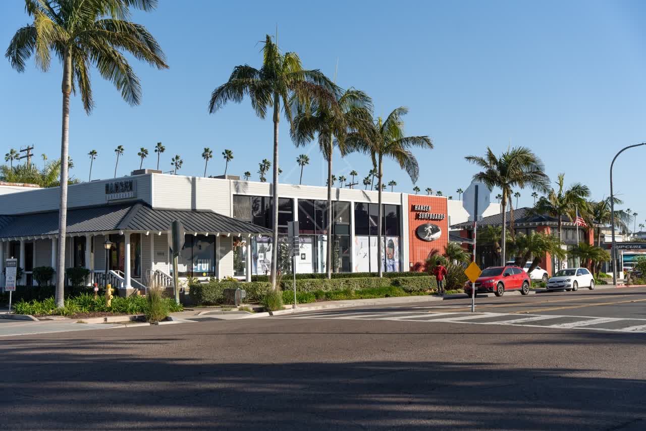 The downtown streets, palm trees and the buildings at Downtown Encinitas, with people walking.