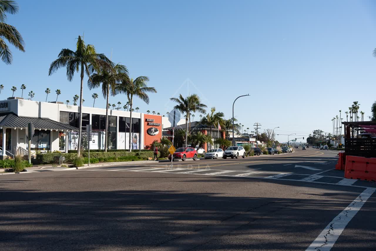 The downtown streets, palm trees and the buildings at Downtown Encinitas, with people walking.