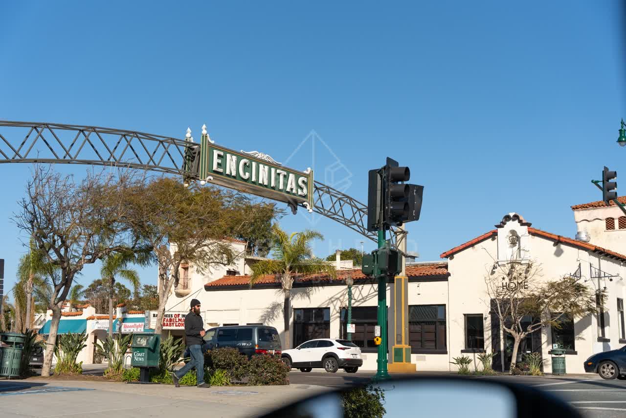 The downtown streets, palm trees and the buildings at Downtown Encinitas, with people walking.