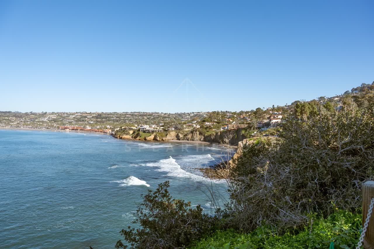 Elevated view of the cliffs, the surf and the pier at La Jolla Cove.