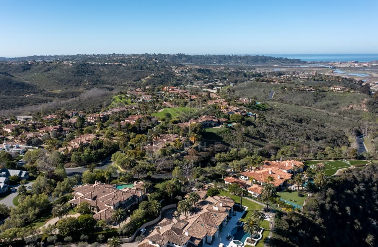 Aerial view of a residential street, palm trees and the ocean at Rancho Pacifica.
