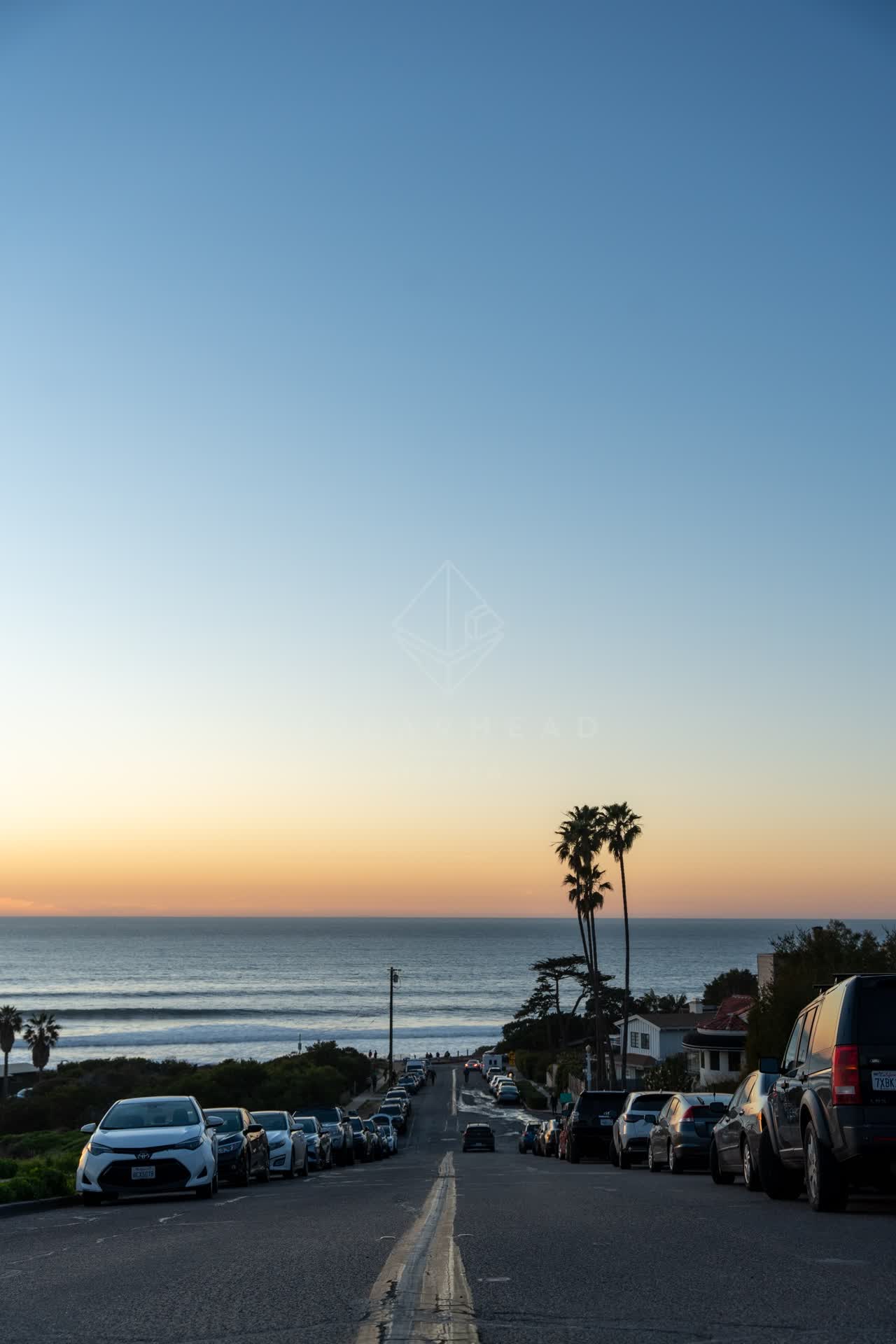 Elevated view of a residential street, the surf and palm trees at Sunset Cliffs.