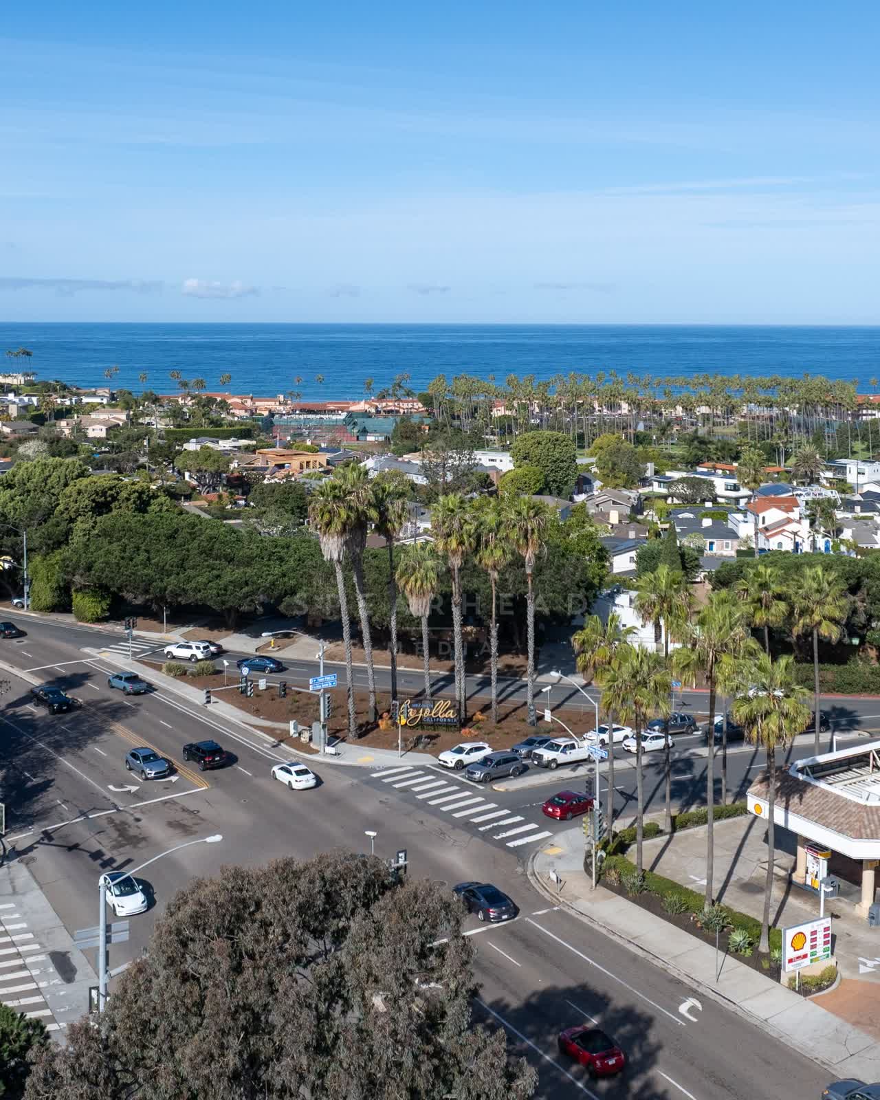 Aerial view of a residential street, palm trees and the ocean in La Jolla.