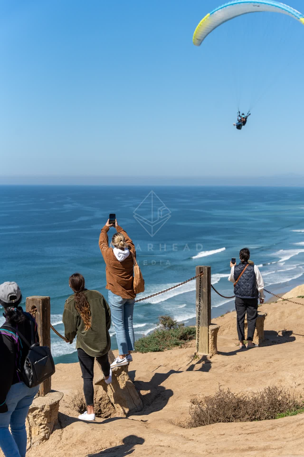 Elevated view of the cliffs, the ocean and open country at Torrey Pines, with a crowd gathered.
