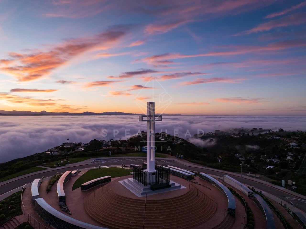 Low aerial view of the cliffs, homes and open country at Mount Soledad.
