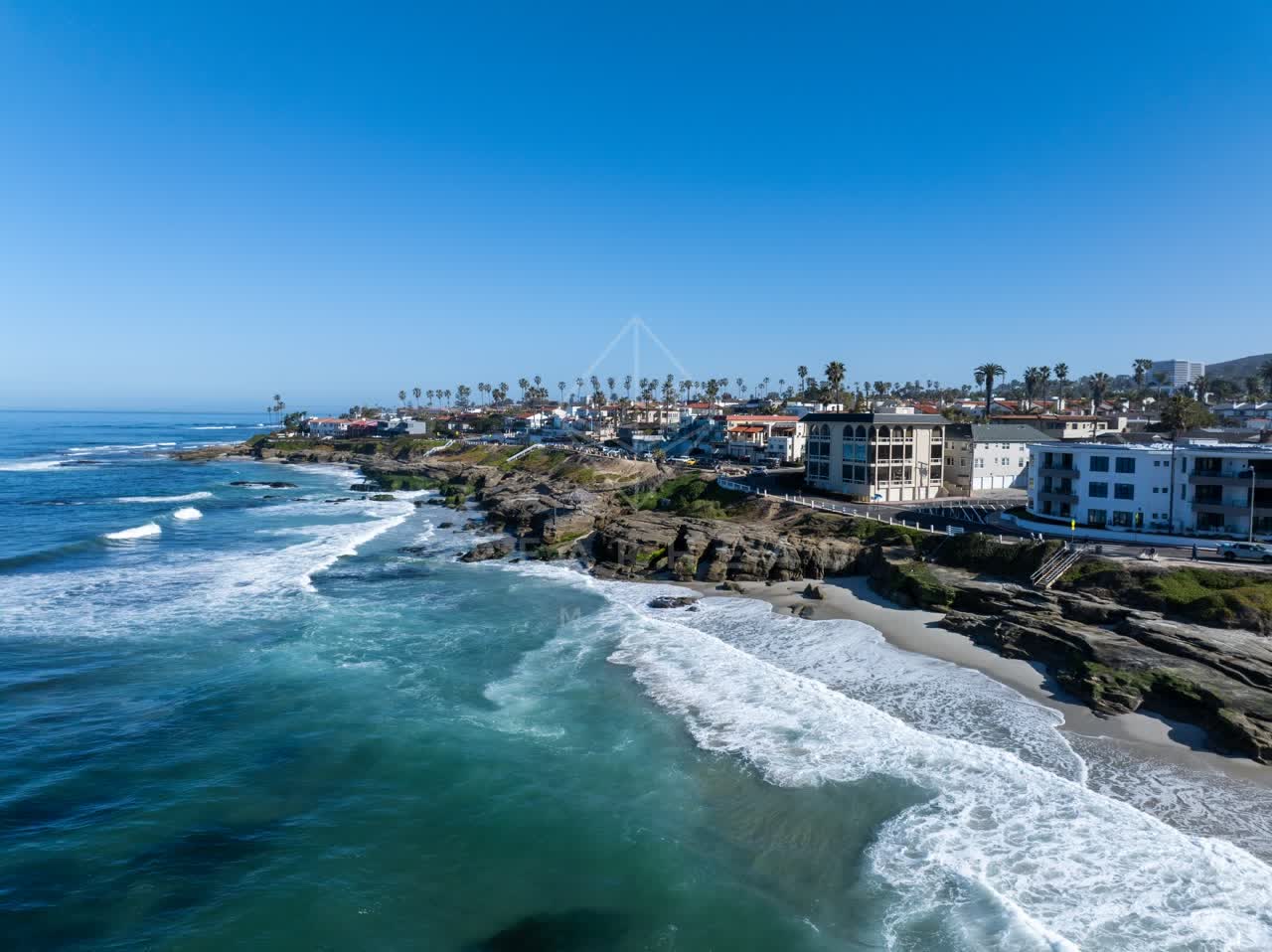 Aerial view of the beach, the surf and palm trees at Windansea.