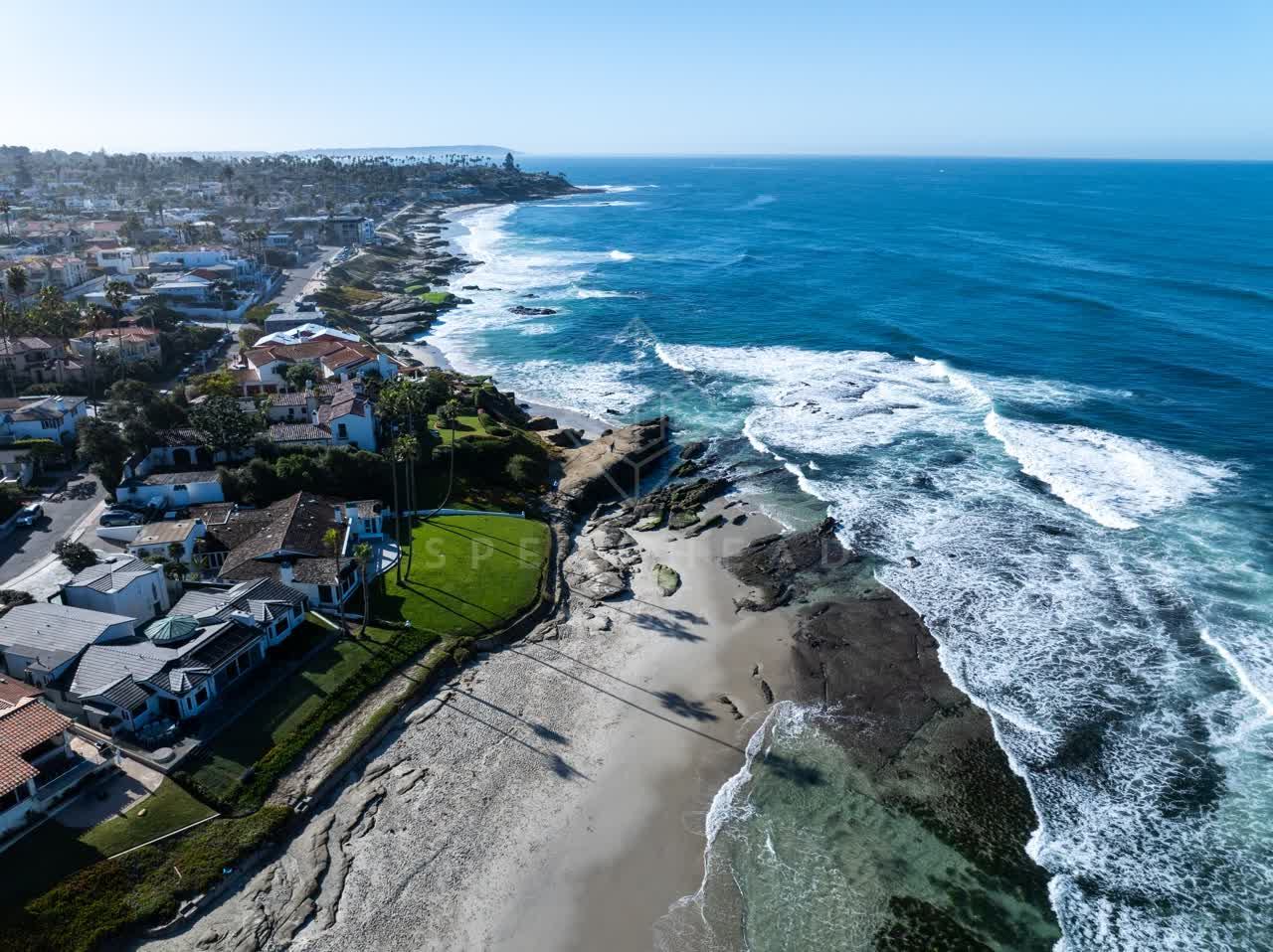 Aerial view of the beach, the surf and palm trees at Windansea.