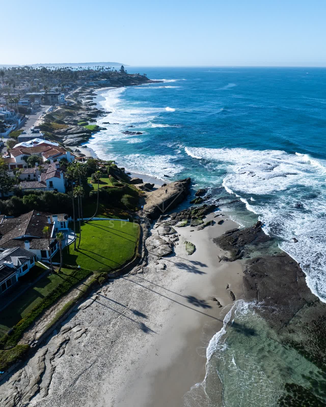 Aerial view of the beach, the surf and palm trees at Windansea.