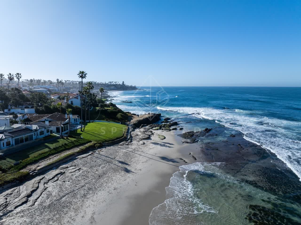 Aerial view of the beach, the surf and palm trees at Windansea.
