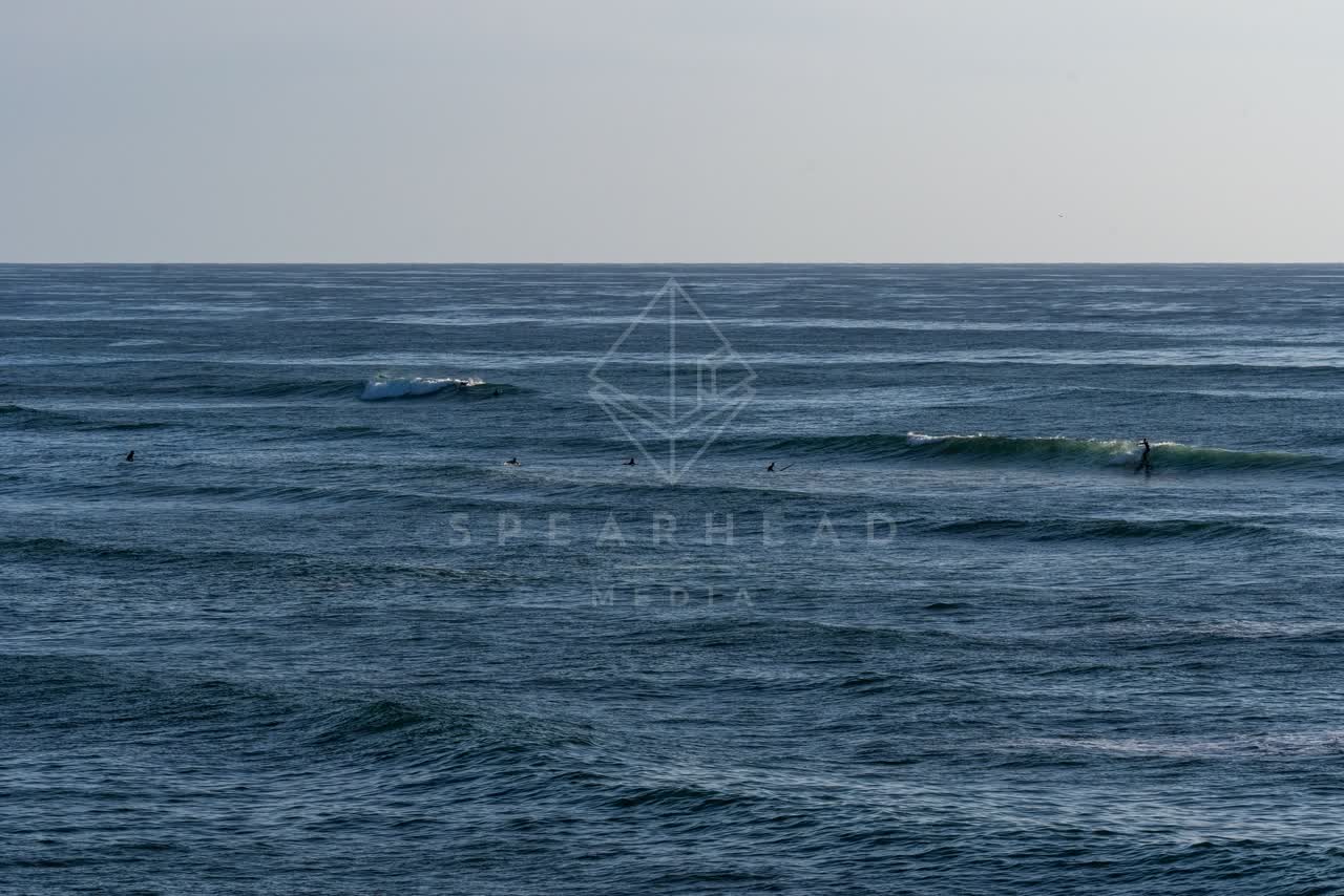The beach, the surf and the ocean at Sunset Cliffs, with surfers out.