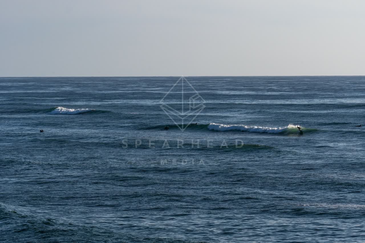 The cliffs, the surf and the ocean at Sunset Cliffs, with surfers out.