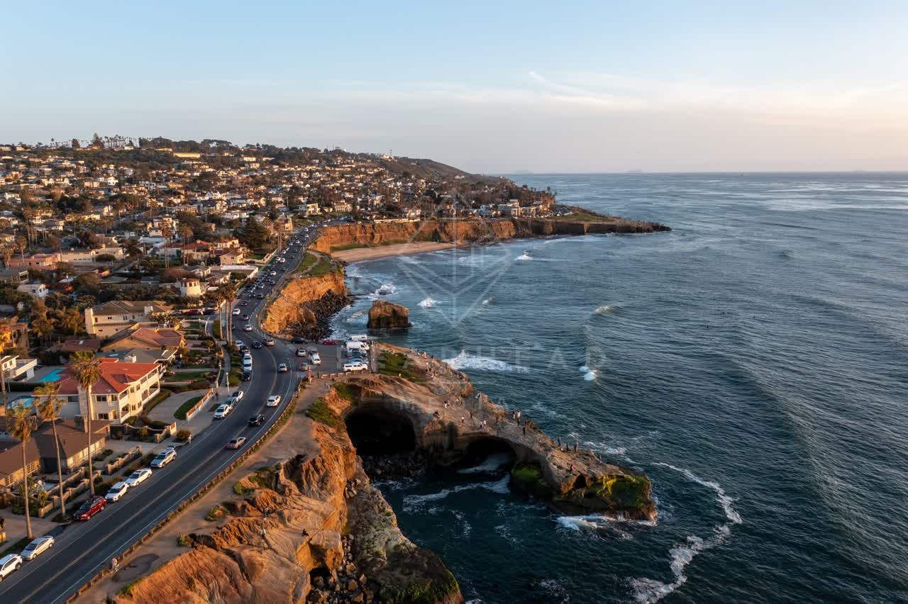 Aerial view of the cliffs, the ocean and homes at Sunset Cliffs, with people walking.