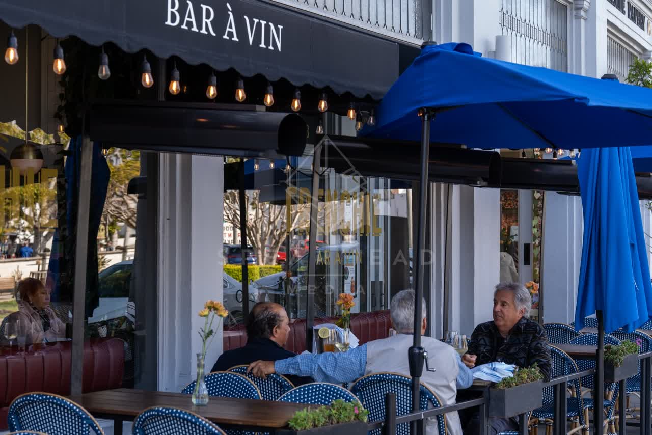 The downtown streets, the buildings and the city in Coronado, with people eating outside.
