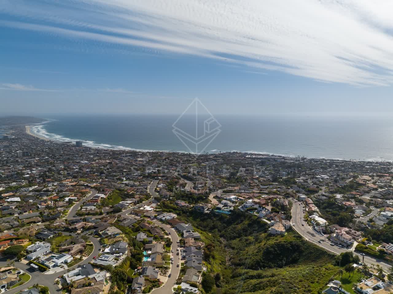 Aerial view of a residential street, the ocean and homes at La Jolla Mesa.