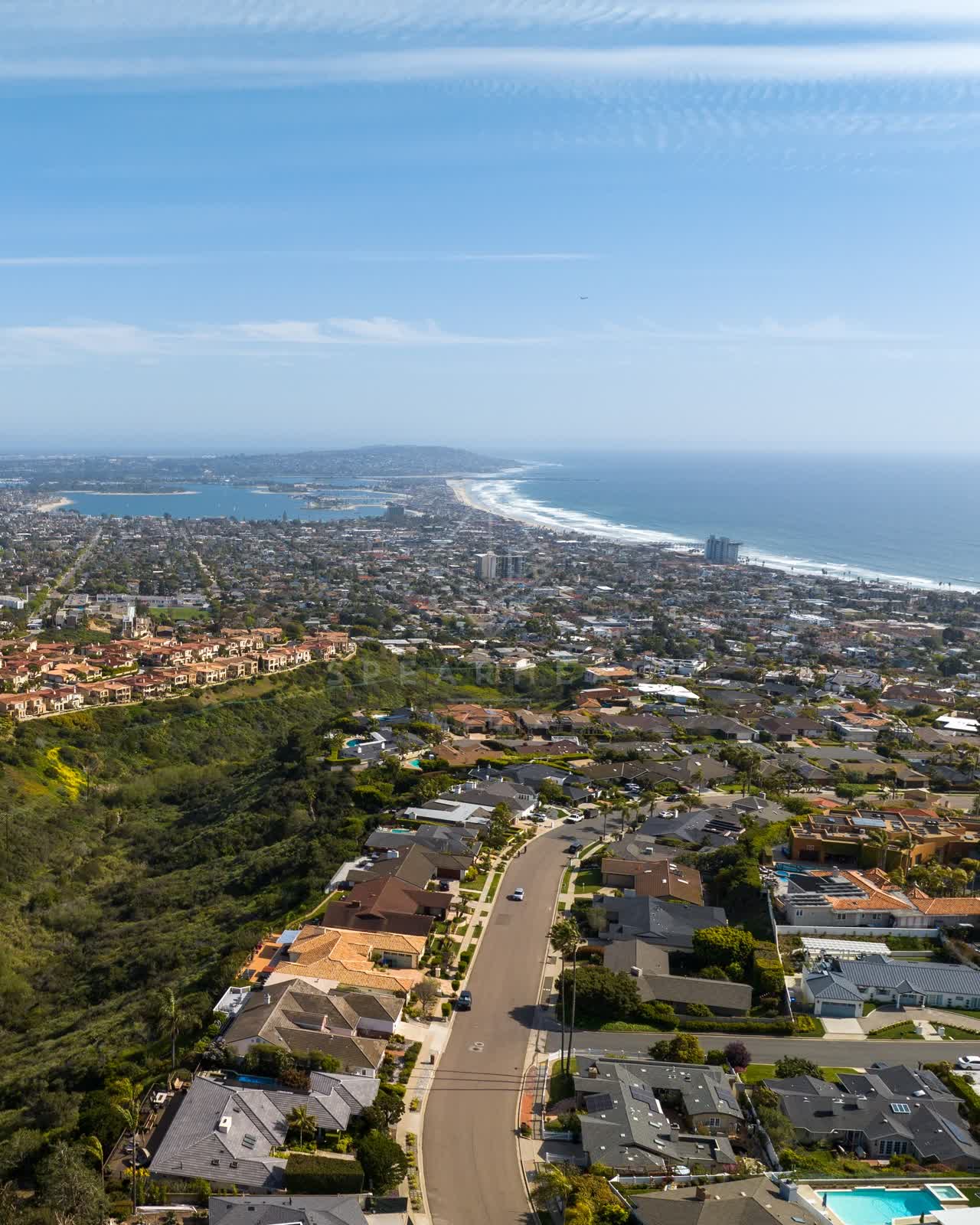 Aerial view of a residential street, the ocean and the bay at La Jolla Mesa.