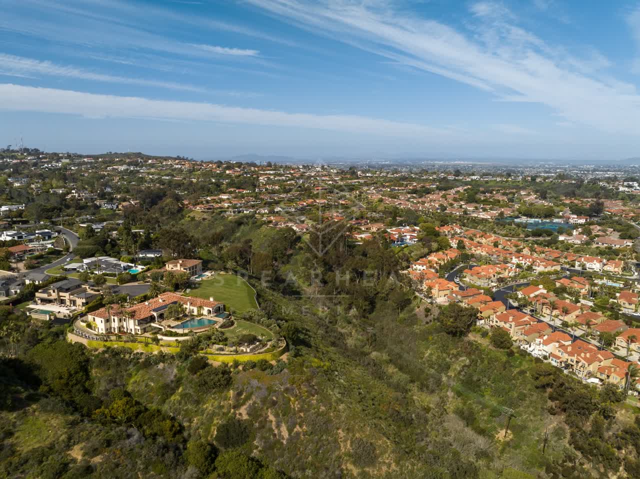 Aerial view of a residential street, homes and open country at La Jolla Mesa.