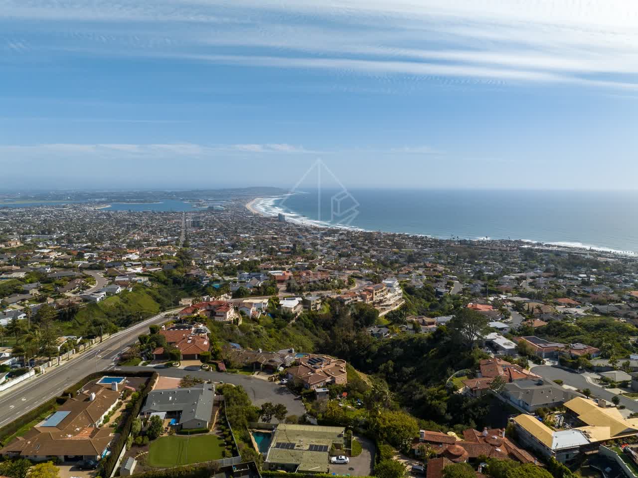 Aerial view of a residential street, palm trees and the ocean at La Jolla Mesa.