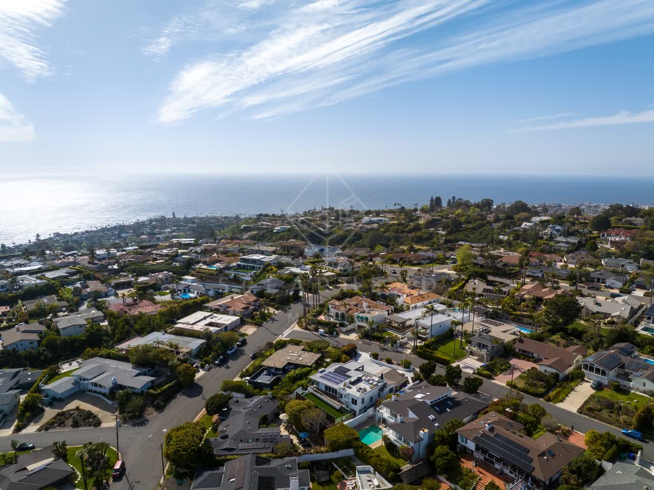 Aerial view of a residential street, palm trees and the ocean at La Jolla Mesa.