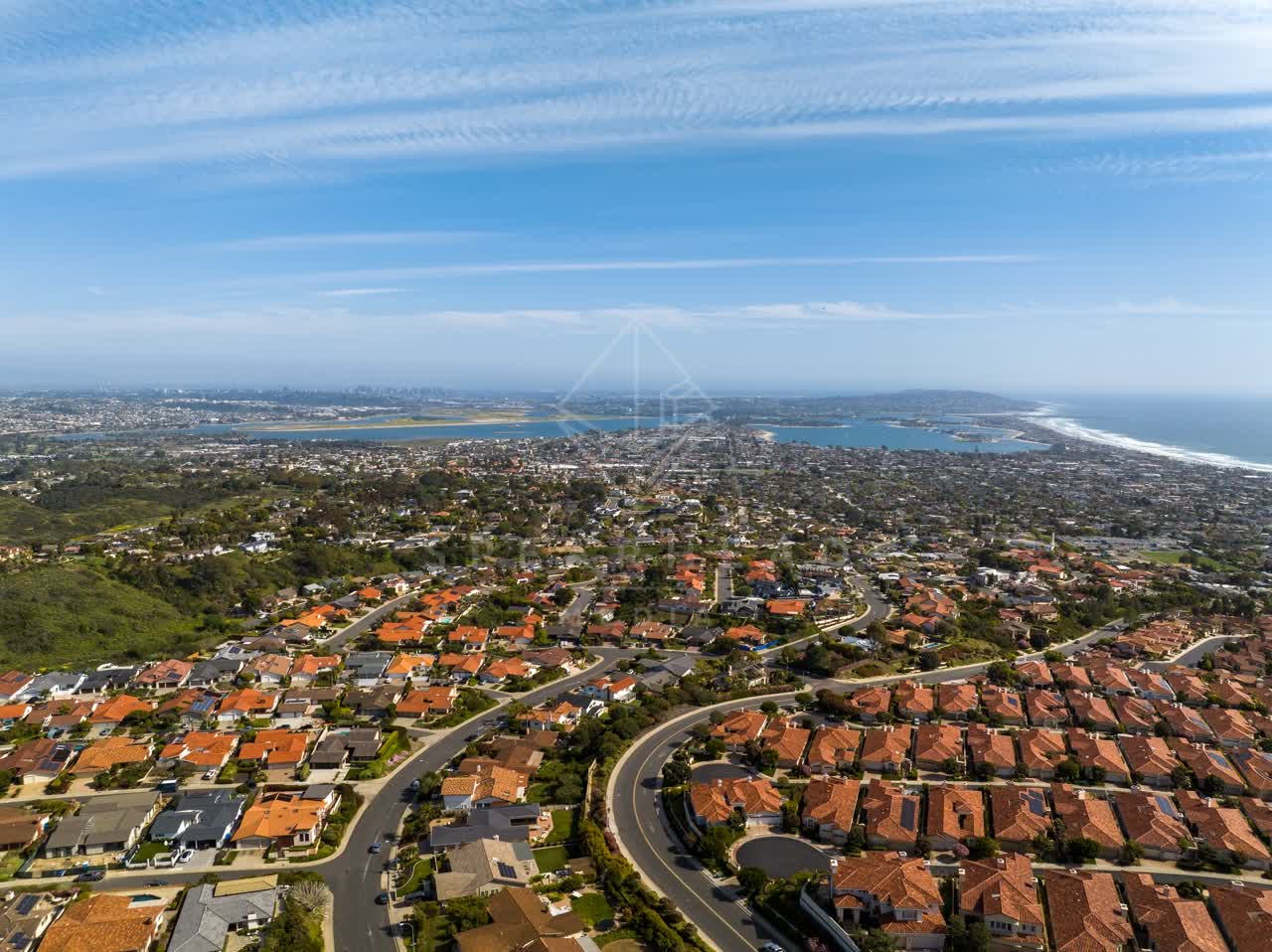 Aerial view of a residential street, the skyline and the ocean at La Jolla Alta.