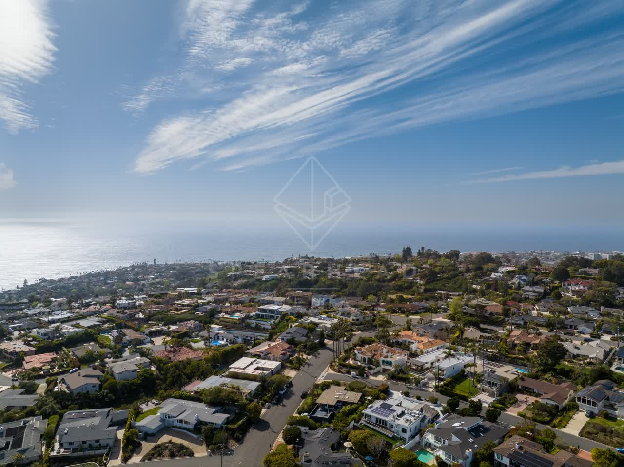 Aerial view of a residential street, palm trees and the ocean at La Jolla Mesa.