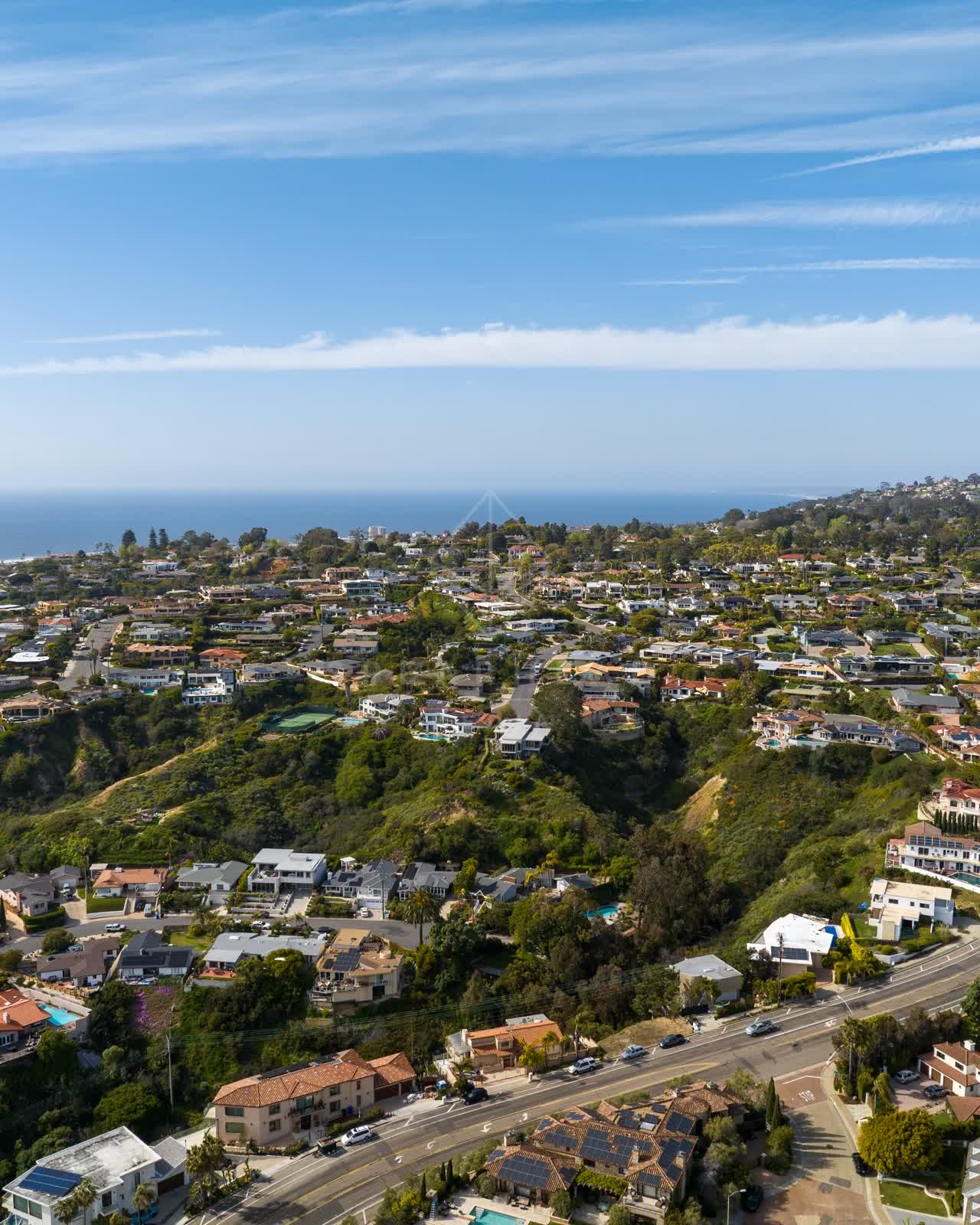 Aerial view of a residential street, the ocean and homes at La Jolla Mesa.
