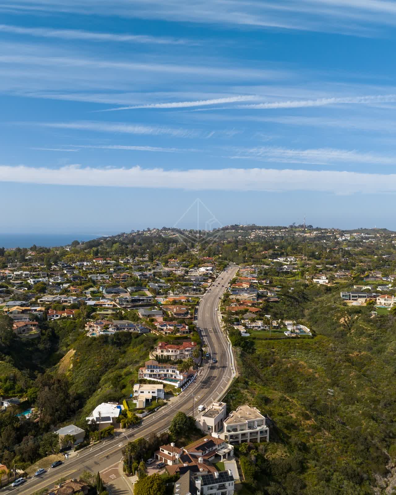 Aerial view of a residential street, the ocean and homes at La Jolla Mesa.