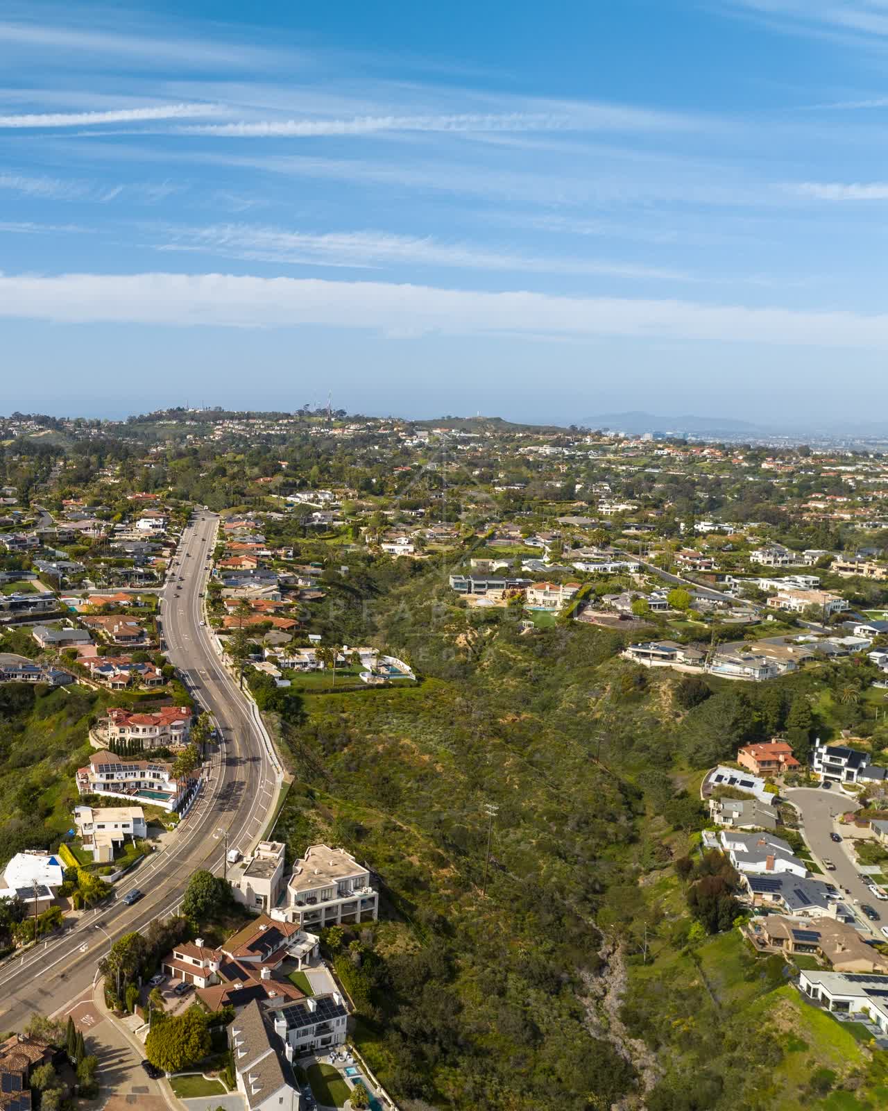 Aerial view of a residential street, homes and the buildings at La Jolla Mesa.
