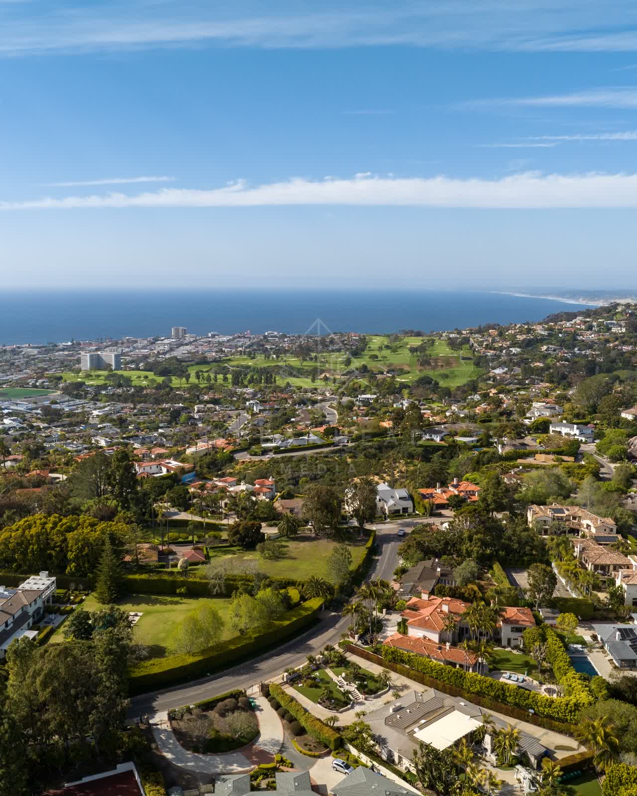 Aerial view of a residential street, the ocean and homes at La Jolla Mesa.