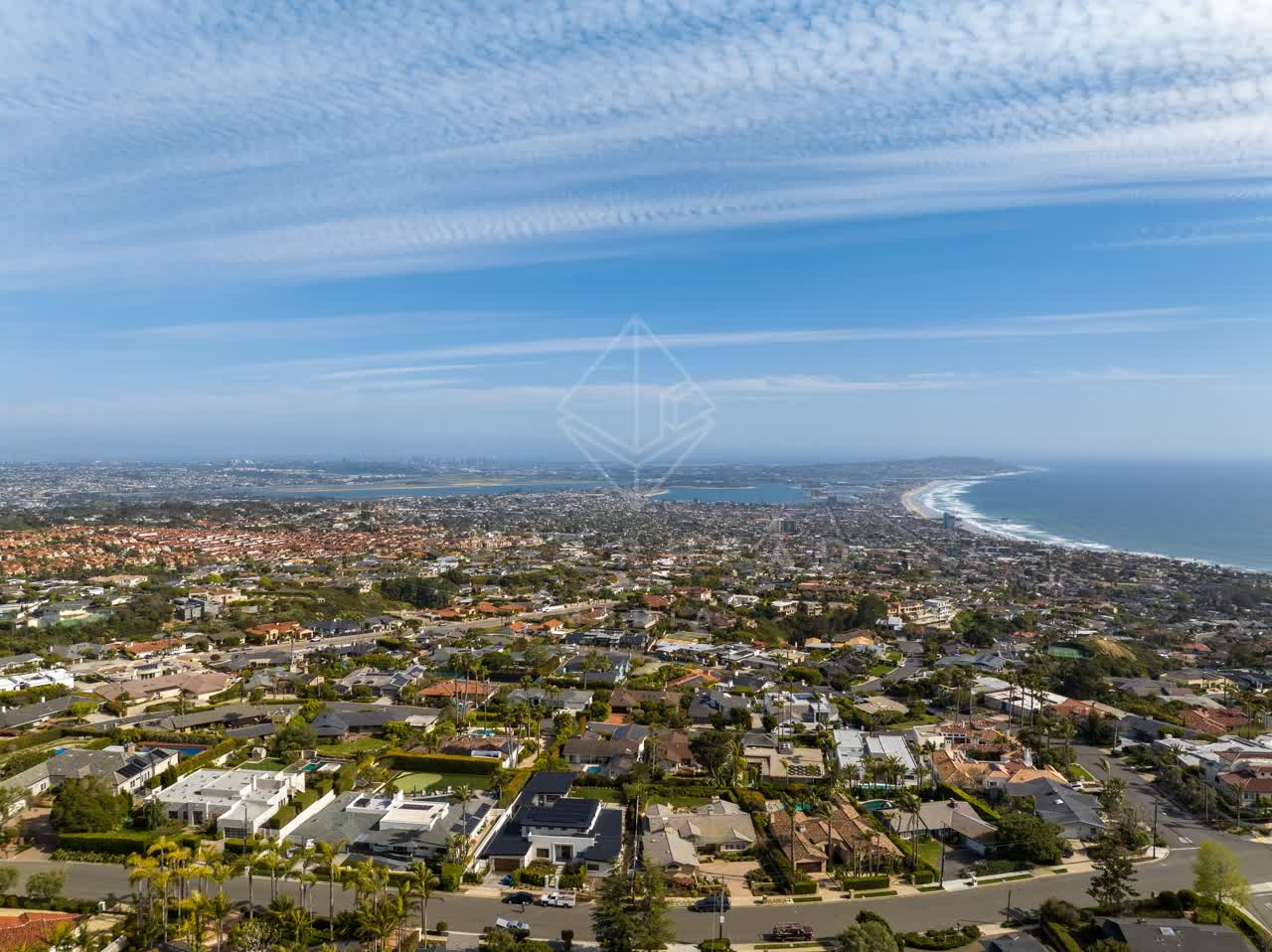 Aerial view of a residential street, palm trees and the ocean at La Jolla Mesa.