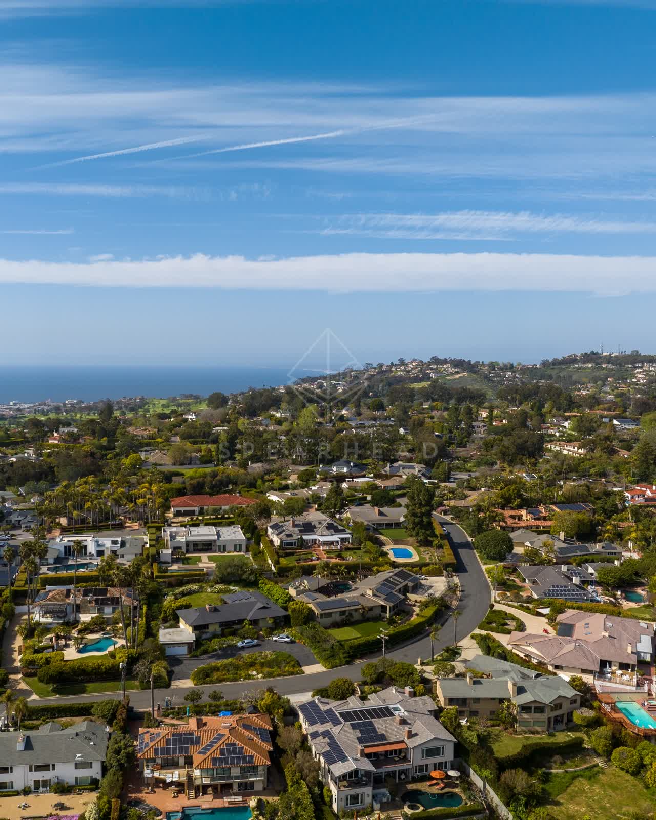 Aerial view of a residential street, palm trees and the ocean at La Jolla Mesa.